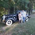 The 1936 Packard Ricky & Ashley pose in front of a 1936 Packard